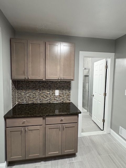 kitchen featuring dark stone counters and backsplash