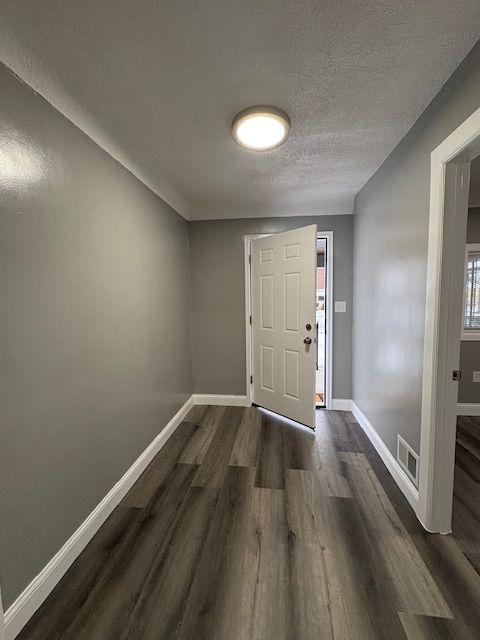 foyer featuring dark hardwood / wood-style flooring and a textured ceiling