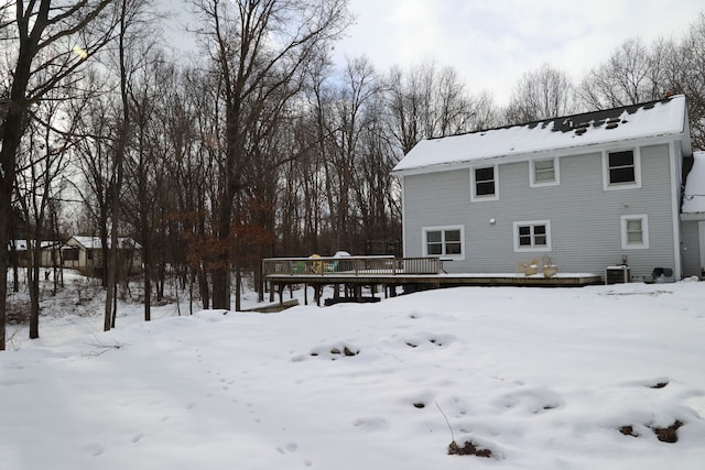 snow covered back of property featuring a deck and central air condition unit