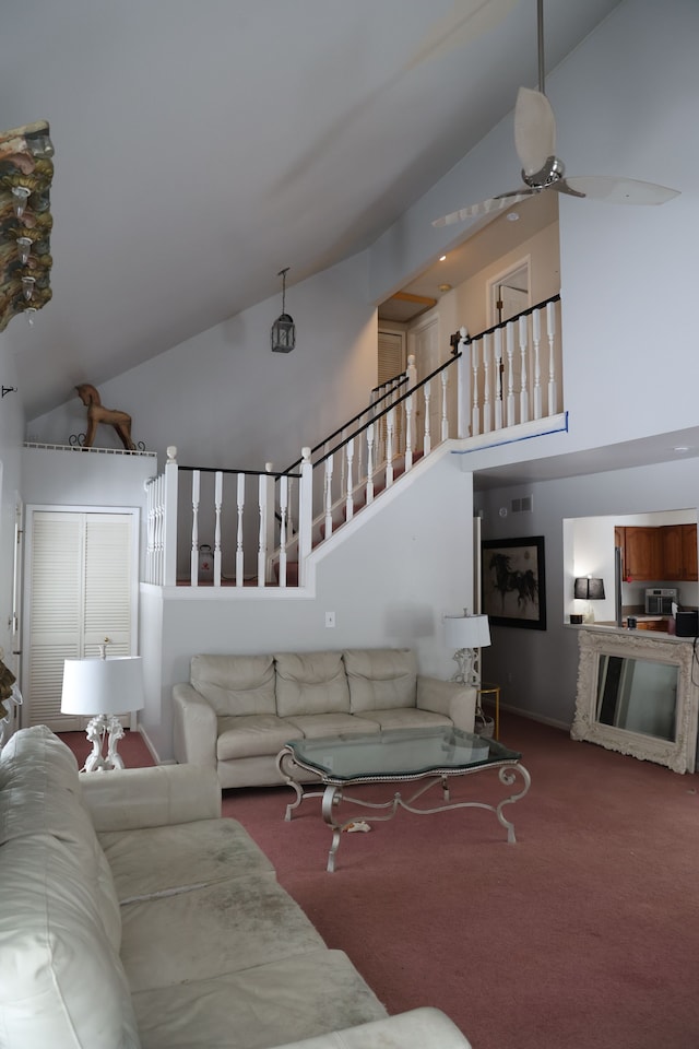 carpeted living room with high vaulted ceiling