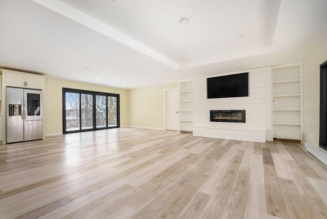 unfurnished living room featuring a large fireplace and light wood-type flooring