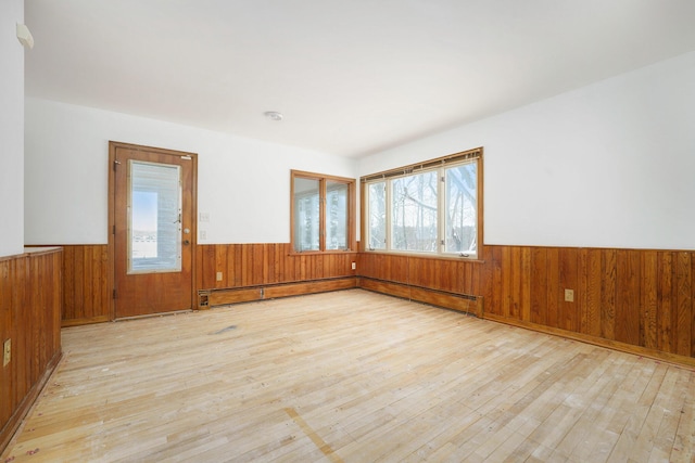 spare room with a baseboard heating unit and light wood-type flooring