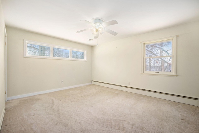 spare room with ceiling fan, light colored carpet, and a baseboard heating unit