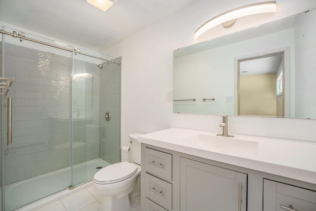 bathroom featuring vanity, tile patterned flooring, toilet, and walk in shower