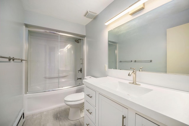 full bathroom with toilet, a baseboard heating unit, enclosed tub / shower combo, and vanity