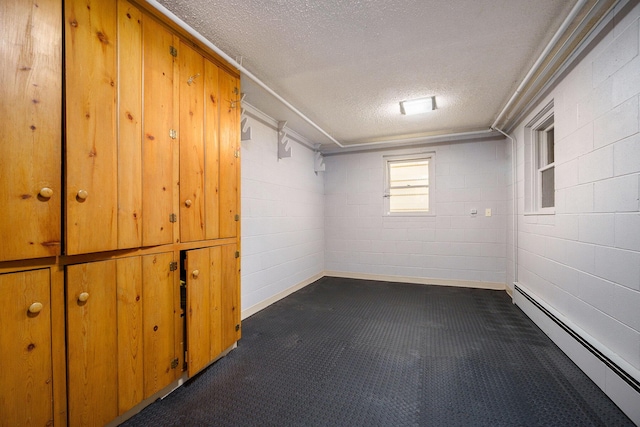 basement featuring a textured ceiling and baseboard heating