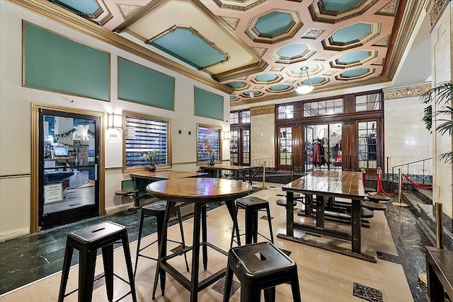 dining space with coffered ceiling, ornamental molding, a towering ceiling, and french doors