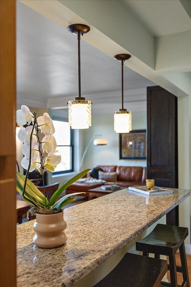 kitchen featuring light stone counters, a breakfast bar area, and pendant lighting