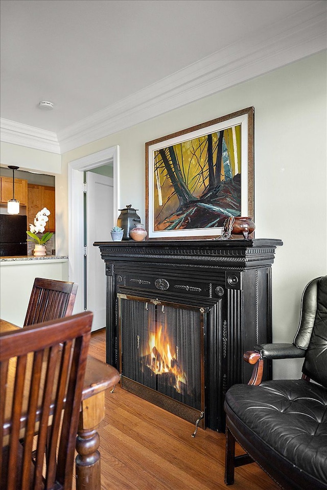 details featuring black refrigerator, wood-type flooring, and ornamental molding