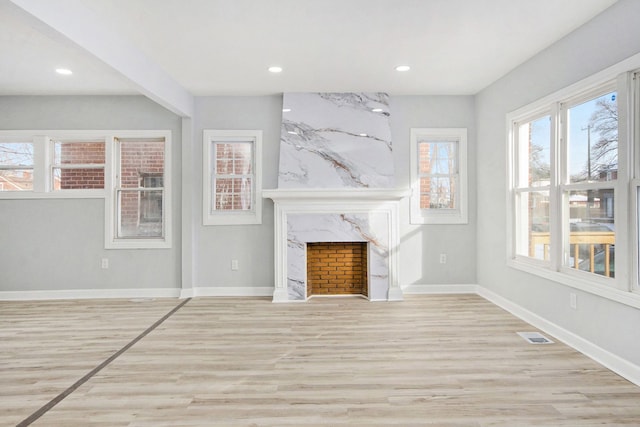 unfurnished living room with light hardwood / wood-style flooring and a fireplace