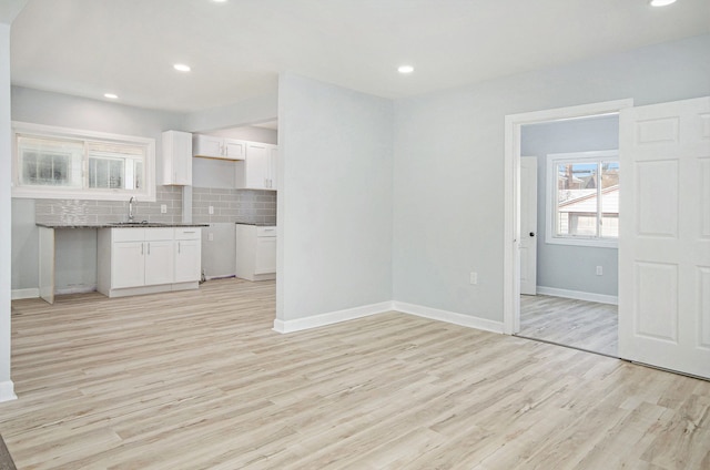 kitchen featuring light hardwood / wood-style floors, sink, white cabinets, and tasteful backsplash