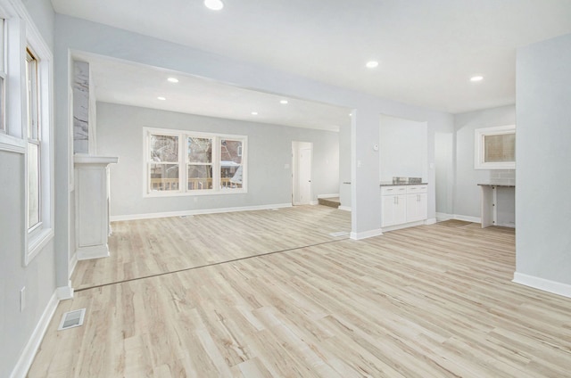 unfurnished living room with plenty of natural light and light hardwood / wood-style flooring