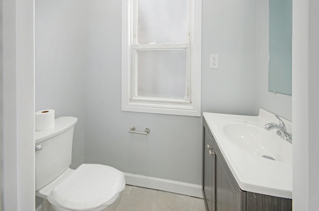 bathroom with toilet, tile patterned floors, and vanity