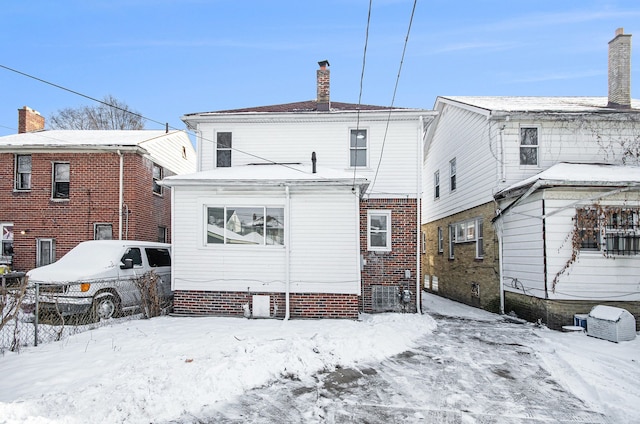 view of snow covered back of property