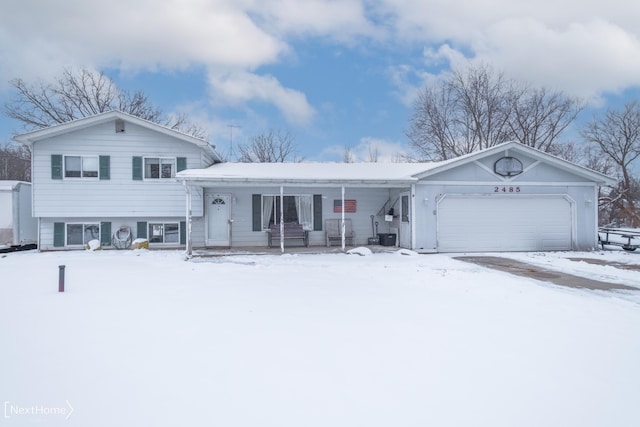 tri-level home with covered porch and a garage