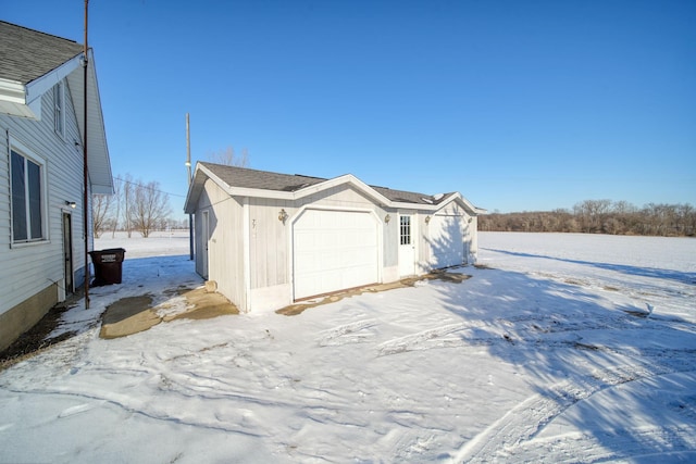 snow covered property with a garage