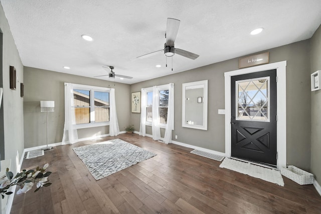 entryway featuring dark wood-type flooring, a textured ceiling, and ceiling fan