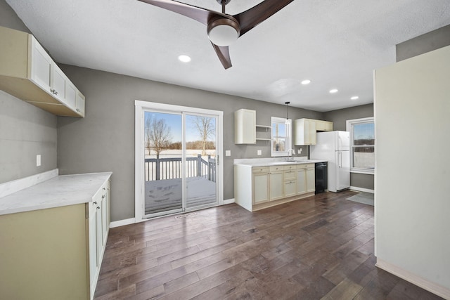 kitchen featuring dishwasher, ceiling fan, pendant lighting, dark wood-type flooring, and sink