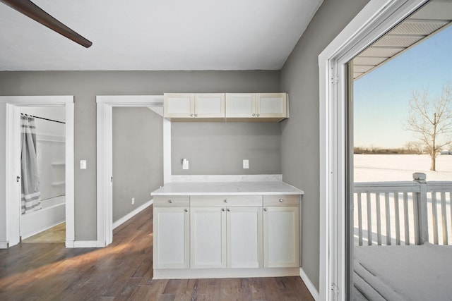 kitchen featuring ceiling fan, dark wood-type flooring, and white cabinetry