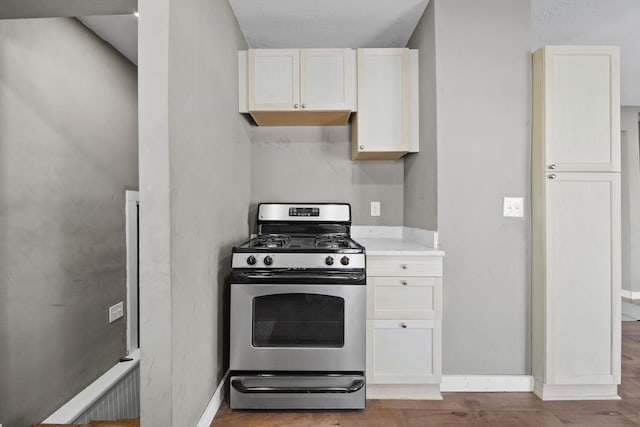 kitchen featuring white cabinets, hardwood / wood-style flooring, and stainless steel range with gas stovetop