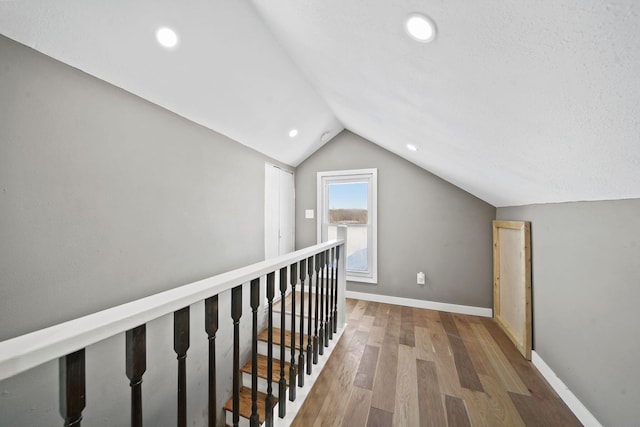 hallway featuring lofted ceiling and wood-type flooring