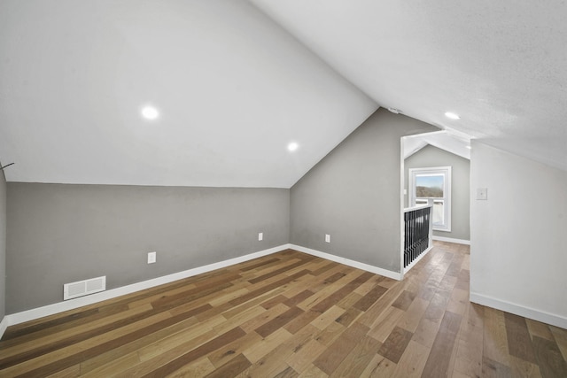 bonus room featuring lofted ceiling and wood-type flooring