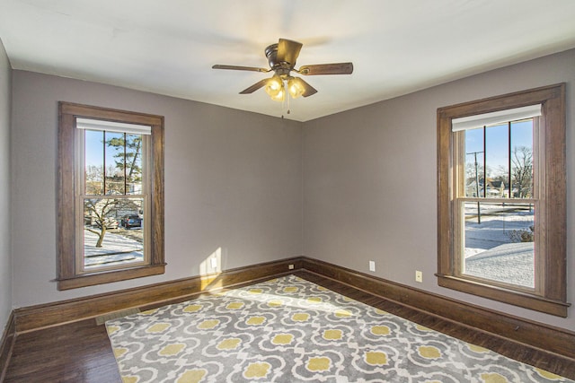 unfurnished room featuring dark wood-type flooring, plenty of natural light, and ceiling fan