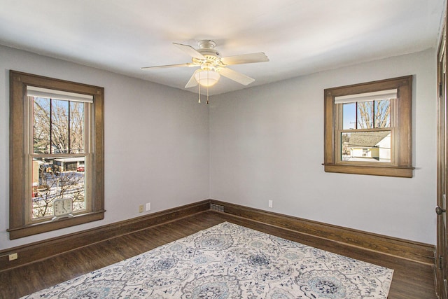 spare room featuring dark hardwood / wood-style floors, plenty of natural light, and ceiling fan