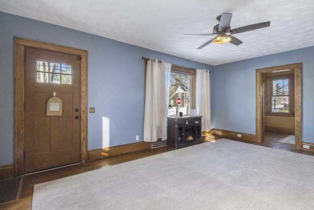 foyer with ceiling fan and a healthy amount of sunlight