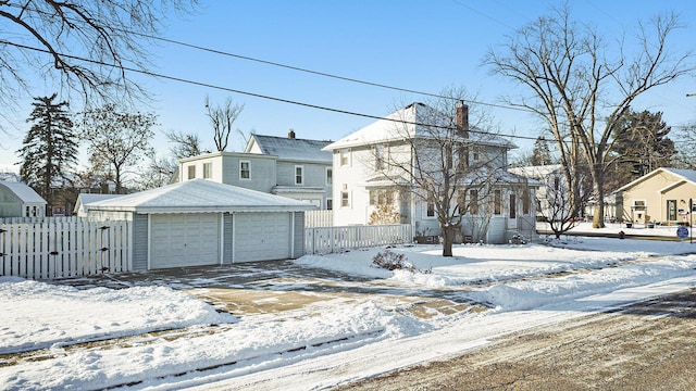 view of property with a garage and an outbuilding