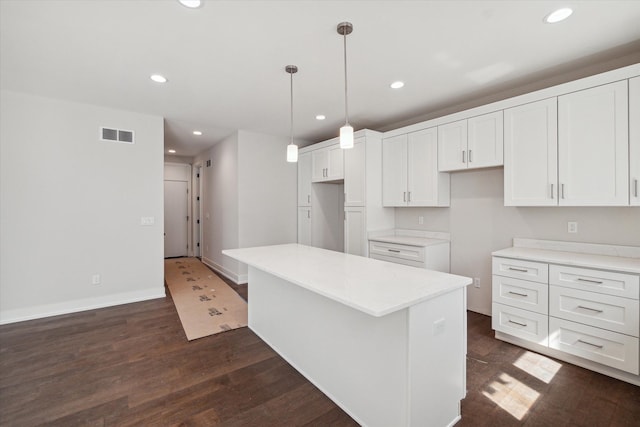 kitchen with decorative light fixtures, white cabinetry, dark hardwood / wood-style flooring, and a center island