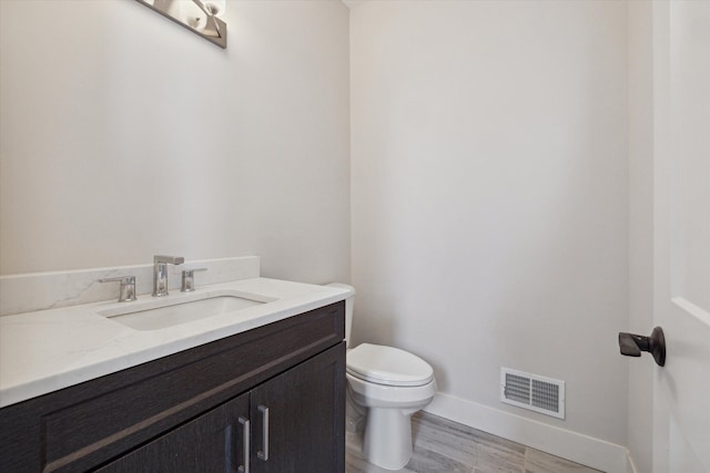 bathroom featuring hardwood / wood-style flooring, vanity, and toilet