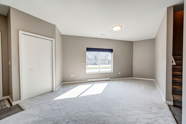 unfurnished bedroom featuring a baseboard radiator, baseboards, and carpet flooring