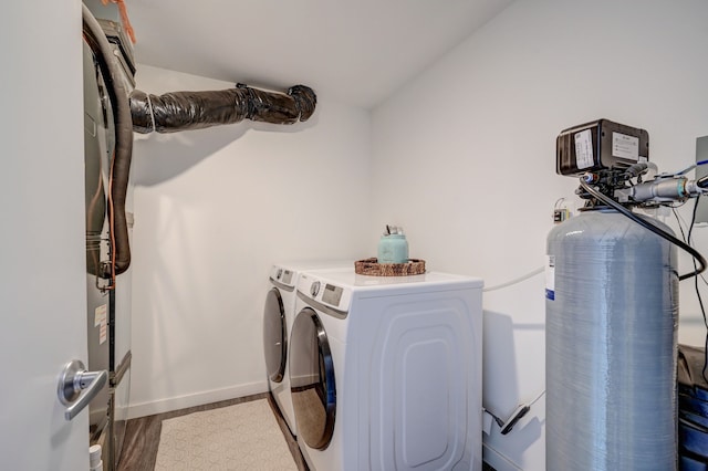 laundry room with laundry area, wood finished floors, separate washer and dryer, and baseboards