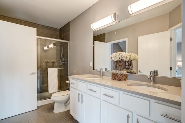 bathroom with a sink, double vanity, and a shower stall