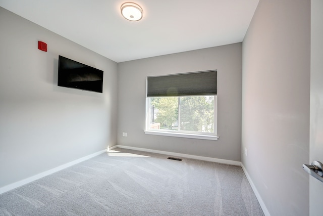 unfurnished room featuring baseboards, visible vents, and carpet floors