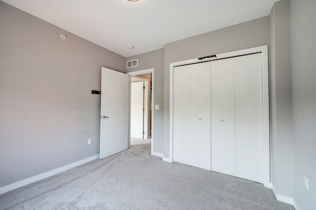 unfurnished bedroom with a closet, visible vents, carpet flooring, and baseboards