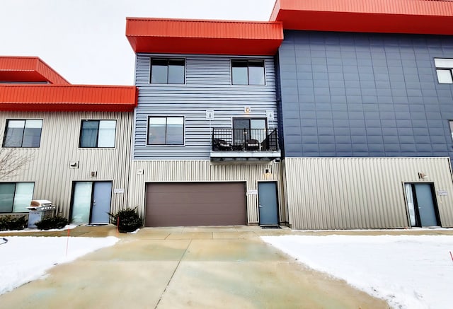 view of front of property with a garage, a balcony, and concrete driveway