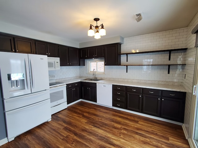 kitchen with an inviting chandelier, tasteful backsplash, white appliances, dark hardwood / wood-style flooring, and sink