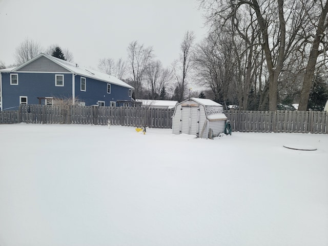 yard layered in snow featuring a storage shed