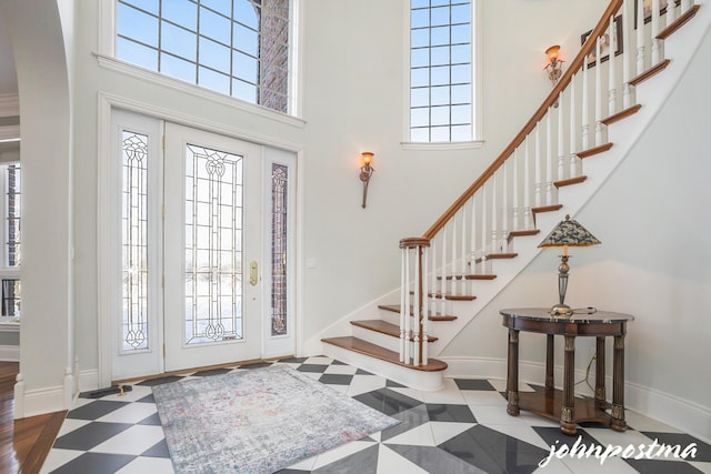 foyer featuring a towering ceiling and a wealth of natural light