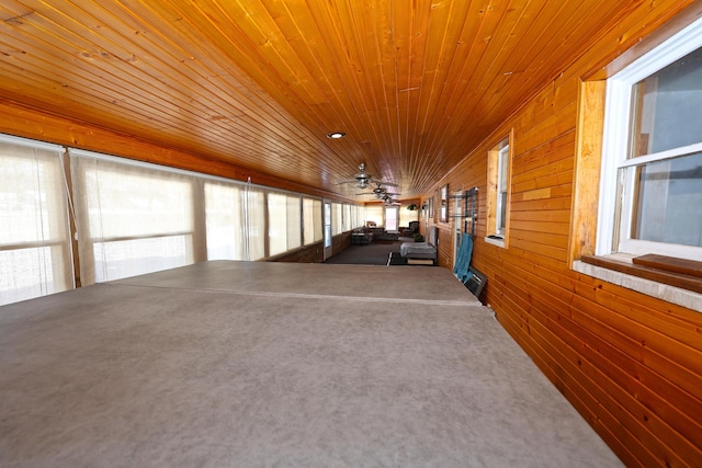 interior space featuring wood walls, ceiling fan, and wood ceiling