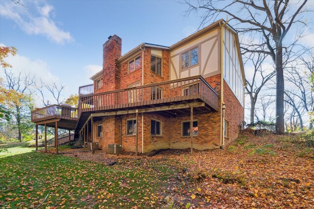 rear view of property with a deck, a yard, and central AC unit