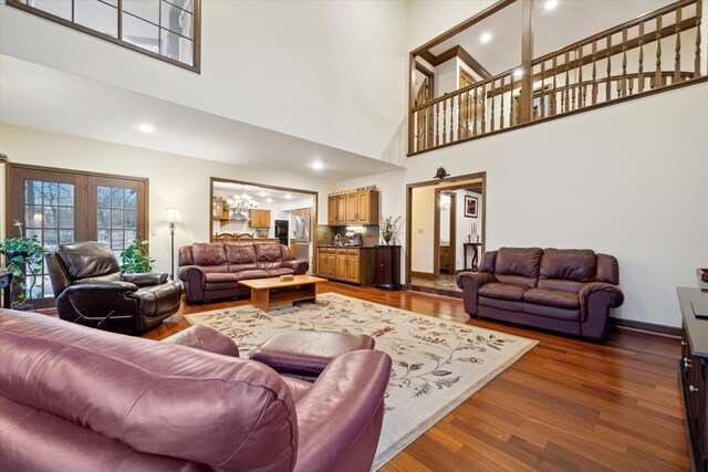 living room with a high ceiling, dark hardwood / wood-style flooring, and french doors