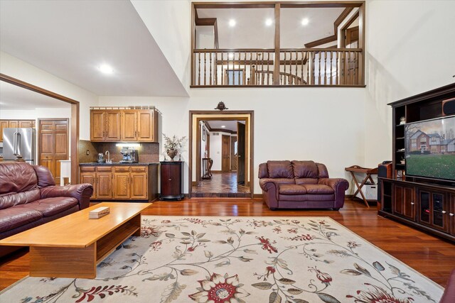 living room featuring a high ceiling and dark hardwood / wood-style flooring