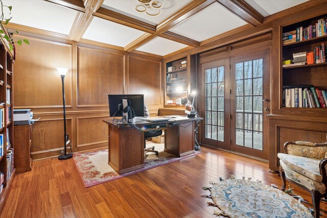 office with beamed ceiling, french doors, light hardwood / wood-style flooring, coffered ceiling, and built in shelves