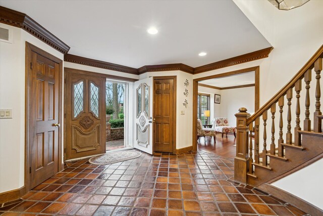 foyer with crown molding and plenty of natural light