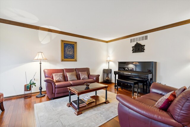 living room with hardwood / wood-style flooring and crown molding