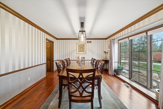 dining room featuring ornamental molding and dark hardwood / wood-style floors