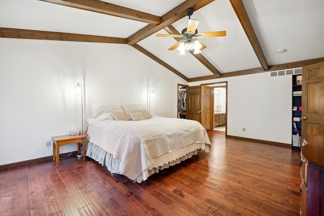 bedroom featuring dark wood-type flooring, ceiling fan, lofted ceiling with beams, and connected bathroom